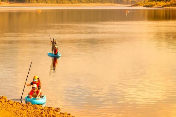 Personas disfrutando de kayak y remo en el embalse El Neusa