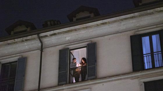 Una pareja en un balcón se suma a otras personas de todo el país para encender una vela por la gente enferma, en Milán, Italia, el 15 de marzo de 2020. (Alessandro Grassani/The New York Times)